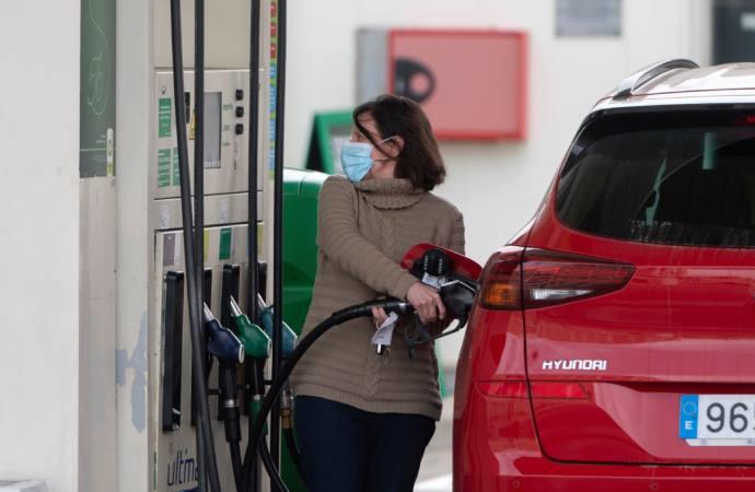 Una mujer reposta combustible en una gasolinera.