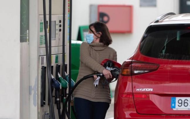 Una mujer reposta combustible en una gasolinera.