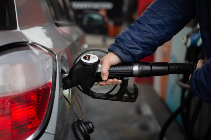 Un hombre reposta gasolina en una estación de servicio.