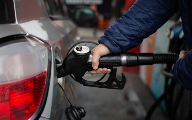 Un hombre reposta gasolina en una estación de servicio.