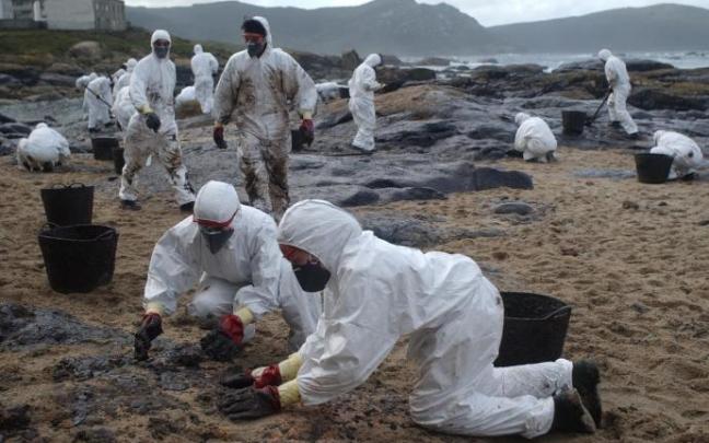 Un grupo de voluntarios limpia una playa tras el vertido del Prestige. Un grupo de voluntarios limpia una playa tras el vertido del Prestige.