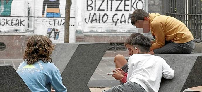 Varios jóvenes mirando un móvil. Foto: Josu Chavarri