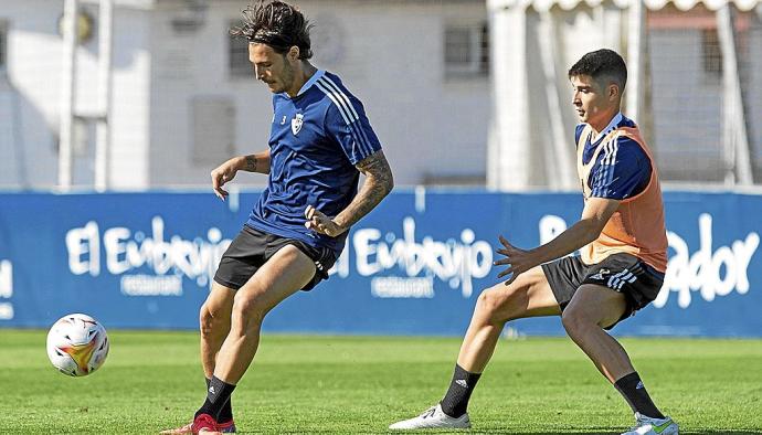 Juan Cruz, con el balón ante la presencia de Jaume Grau en el entrenamiento matinal de ayer en Tajonar. Foto: CA Osasuna