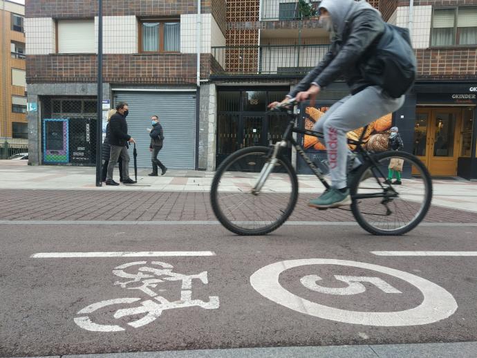 Un ciclista pasa por el bidegorri que está en la calle Sabino Arana.