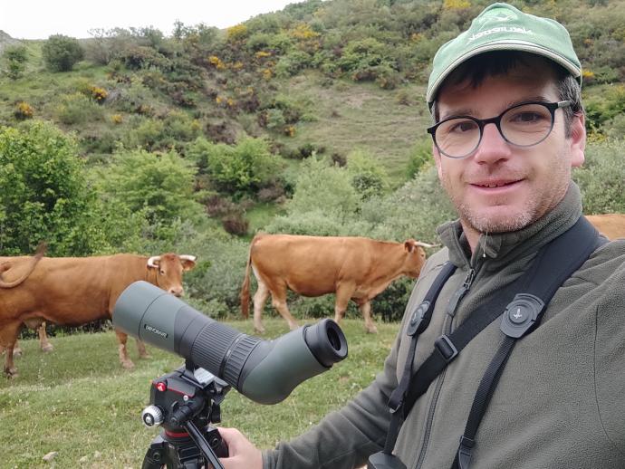 Pablo Pérez, en una de sus rutas por la naturaleza con unas vacas detrás.