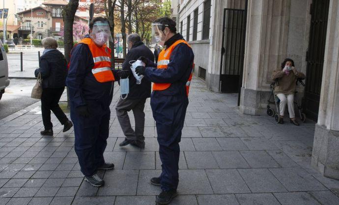 Miembros de Protección Civil repartiendo mascarillas a la entrada del Ambulatorio Doctor San Martín, durante el estado de alarma decretado por coronavirus.