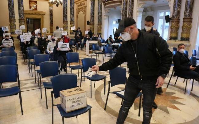 Un agente "vota" en una urna de cartón a favor de la dimisión del director y el concejal de la Guardia Municipal mientras se desarrollaba el Pleno de este miércoles.