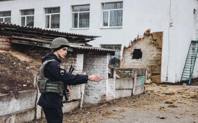 Un policía da instrucciones frente a una guardería donde ha impactado un proyectil en Stanitsa Luganska.