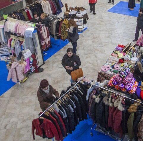 Personas echando un vistazo a unos puestos de ropa en Dendaraba.