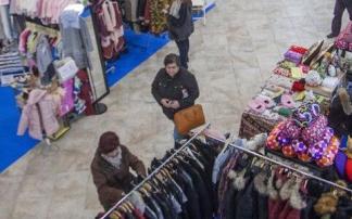 Personas echando un vistazo a unos puestos de ropa en Dendaraba.