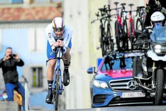 Filippo Ganna, durante la contrarreloj de la Tirreno-Adriático, seguido por un coche colmado de bicicletas.