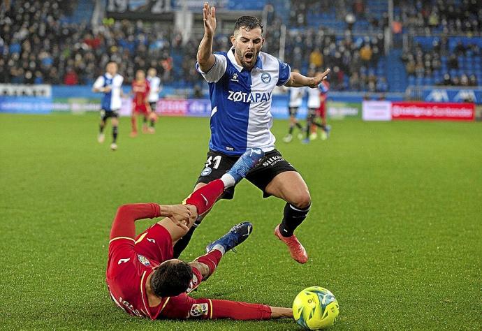 Luis Rioja trata de pasar por encima de Iglesias en el último duelo entre el Alavés y el Getafe. Foto: Josu Chavarri