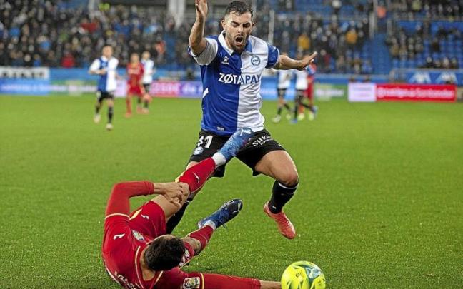 Luis Rioja trata de pasar por encima de Iglesias en el último duelo entre el Alavés y el Getafe. Foto: Josu Chavarri