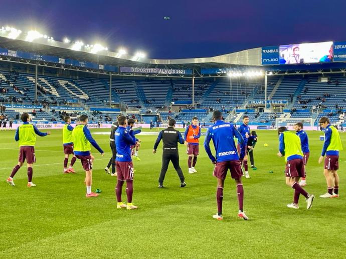 Los jugadores de la Real calientan sobre el terreno de juego de Mendizorrotza.