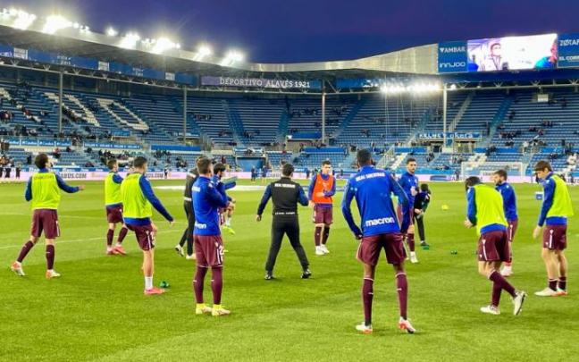 Los jugadores de la Real calientan sobre el terreno de juego de Mendizorrotza.