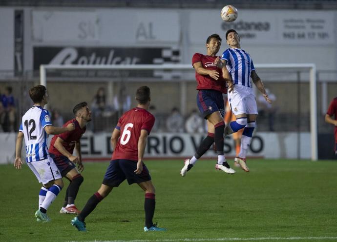Martín Merquelanz salta con un jugador de Osasuna en presencia de Aihen, durante el partido del pasado verano en Irun.