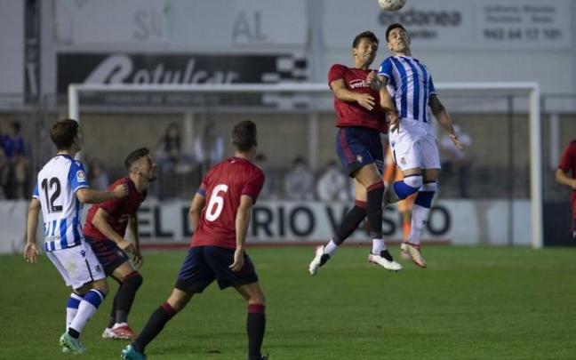 Martín Merquelanz salta con un jugador de Osasuna en presencia de Aihen, durante el partido del pasado verano en Irun.