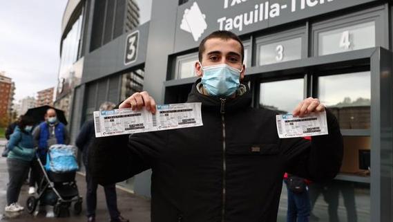 Un aficionado realista muestra sus entradas para El Sadar, este miércoles en Anoeta.