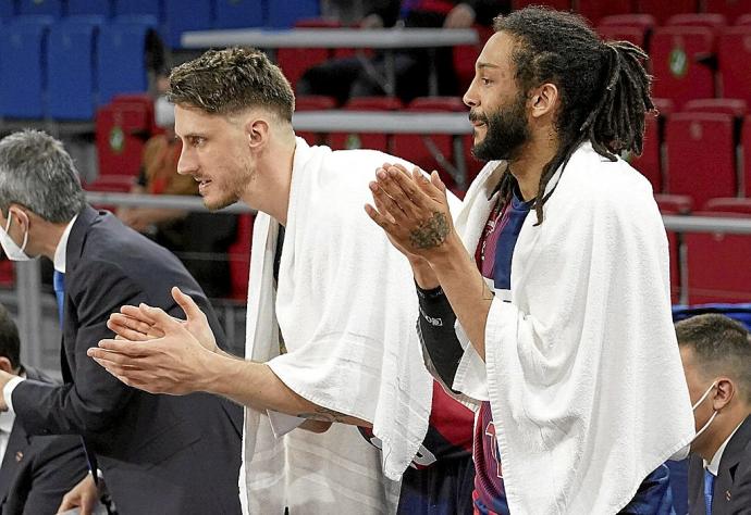 Polonara y Henry, dos de los baluartes de esta temporada recién finalizada, aplauden desde el banquillo a sus compañeros en un partido. Foto: Alex Larretxi