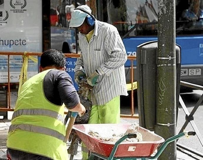Dos hombres trabajan en una obra a pie de calle. Foto: E. P.