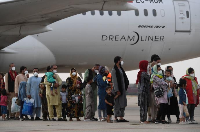 Afganos se disponen a subir a un avión en el aeropuerto de Kabul.
