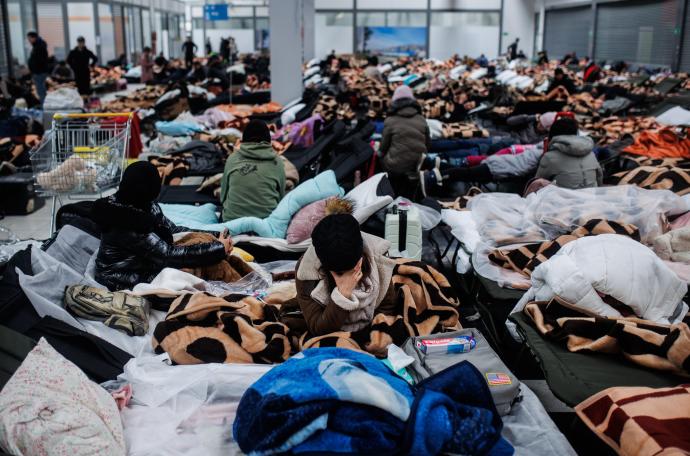 Varias personas descansan en un centro comercial destinado a la acogida temporal de los refugiados, Polonia.