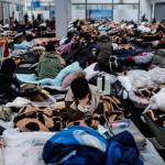 Varias personas descansan en un centro comercial destinado a la acogida temporal de los refugiados, Polonia.