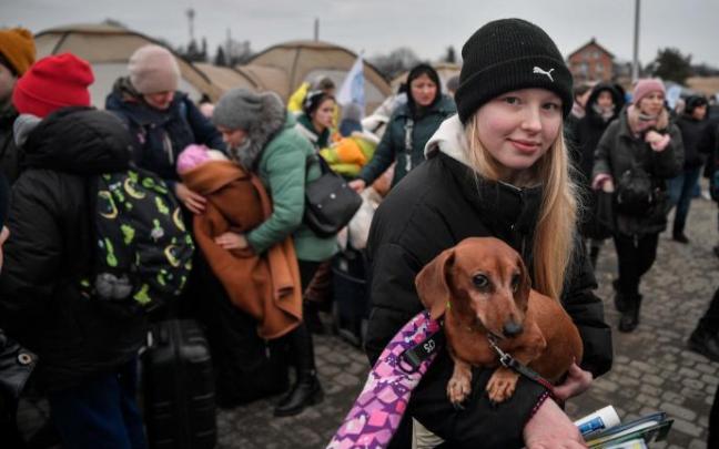 Una refugiada polaca sostiene a su perro en Medyka, al sur de Polonia.