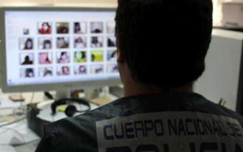 Un agente examina material informático incautado en una operación contra la pornografía infantil.