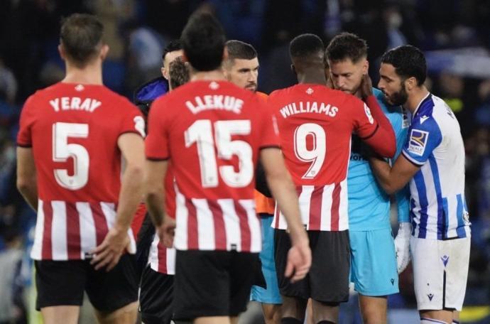 Remiro es consolado por Williams y Merino, entre otros jugadores, al término del derbi del domingo.