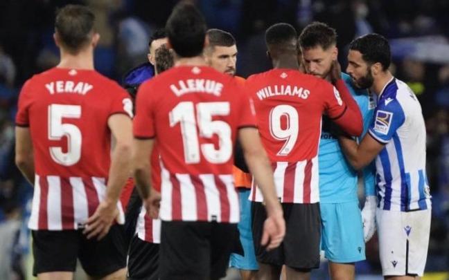 Remiro es consolado por Williams y Merino, entre otros jugadores, al término del derbi del domingo.
