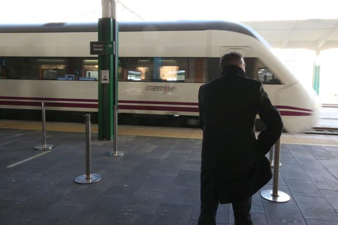 Un hombre esperando para coger un tren en la estación.