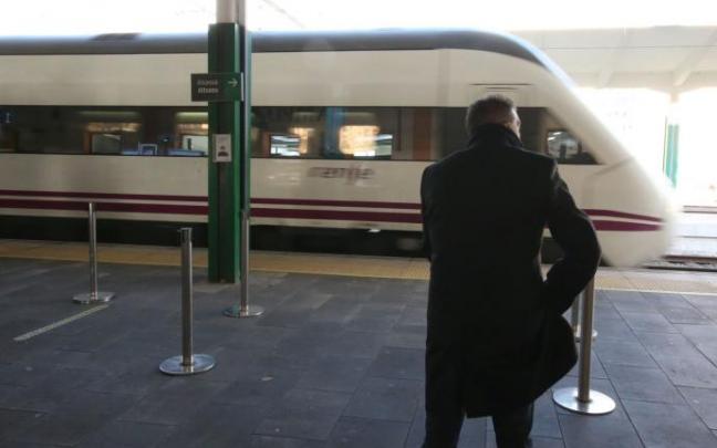 Un hombre esperando para coger un tren en la estación.