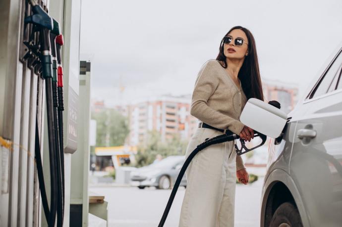 Una mujer echa gasolina a su coche en una estación de servicio.