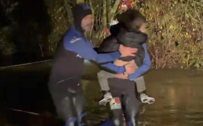 Una bombera sujeta en brazos a la niña