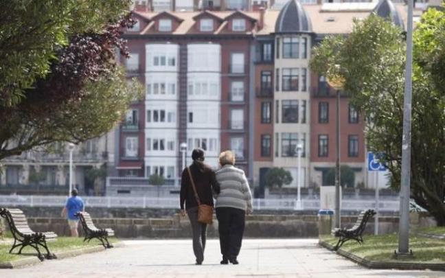 Imagen de archivo de una persona mayor paseando con una cuidadora.