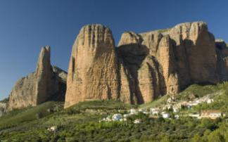 Las colosales paredes de los Mallos parecen proteger al pueblo de Riglos. Las colosales paredes de los Mallos parecen proteger al pueblo de Riglos.