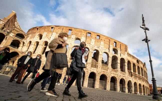 Personas con mascarilla transitan por las inmediaciones del Coliseo de Roma.