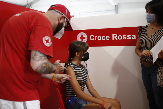 Sanitarios vacunan a una joven en Roma.