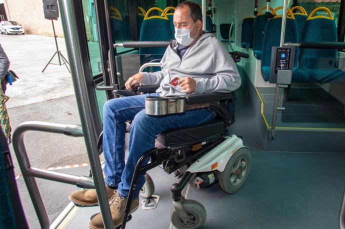 Roberto Labiano, vecino de Pamplona, accede en silla de ruedas a una villavesa para probar las nuevas máquinas incorporadas para personas con movilidad reducida.