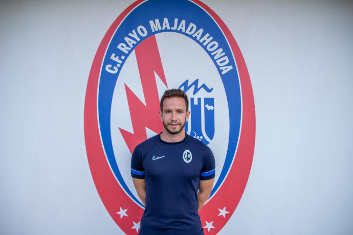 Alberto Valiente posa junto al escudo del Rayo Majadahonda.