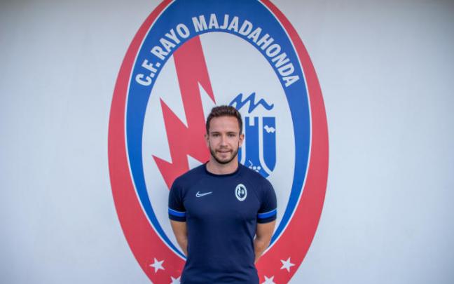 Alberto Valiente posa junto al escudo del Rayo Majadahonda.