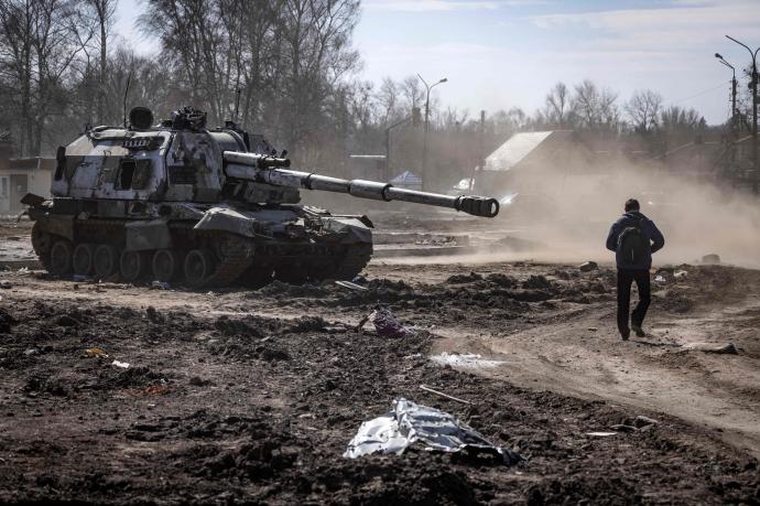 Un hombre pasea junto a un tanque destruido en la ciudad ucraniana de Trostianets.