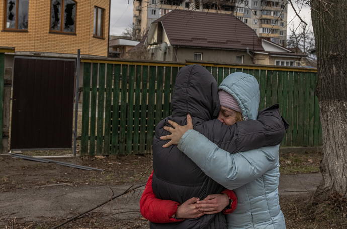 Una mujer llora mientras abraza a su hermana tras el ataque de las tropas rusas a la ciudad.