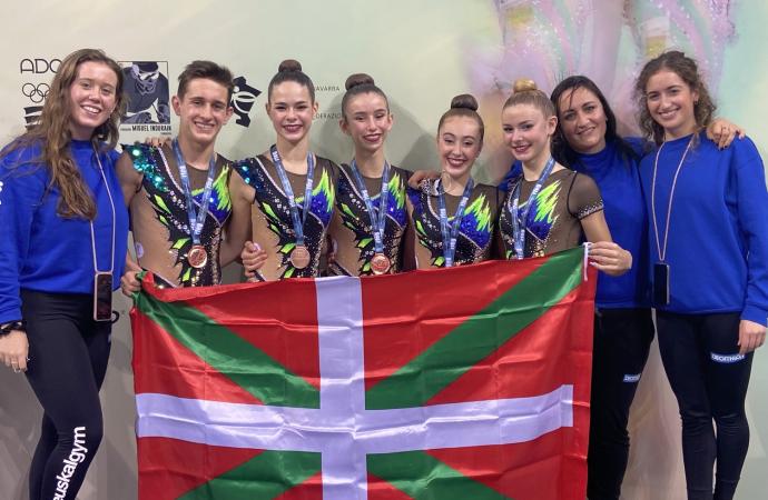 Gimnastas y cuerpo técnico posan felices tras recibir la medalla de bronce.