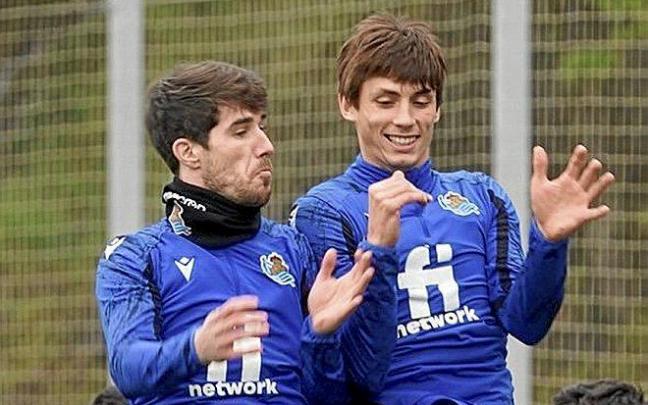 Aritz Elustondo y Robin Le Normand saltan durante un entrenamiento en las instalaciones de Zubieta.