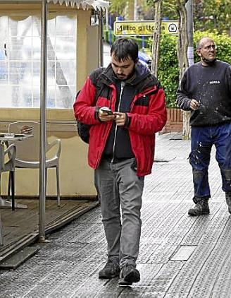 Un joven camina mientras revisa el móvil. Foto: M. Bernal