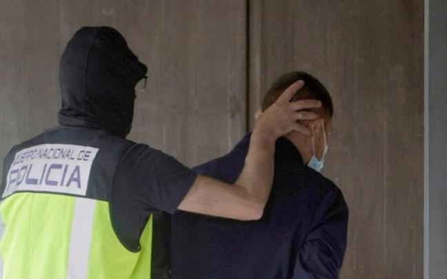 Un agente de policía conduce a uno de los cuatro detenidos por el homicidio de Samuel Luiz a los juzgados Un agente de policía conduce a uno de los cuatro detenidos por el homicidio de Samuel Luiz a los juzgados