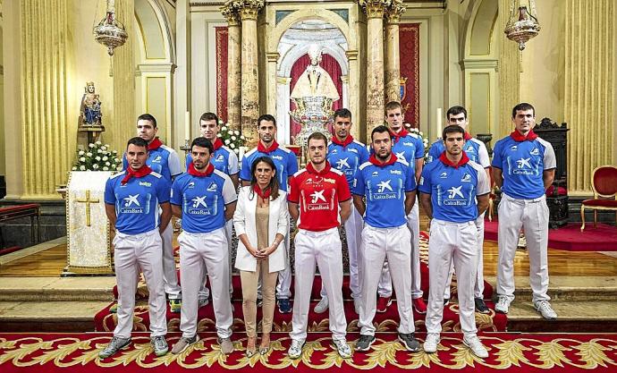 Los doce pelotaris del Torneo de San Fermín junto a Isabel Moreno, de CaixaBank, con el pañuelo sanferminero al cuello, ayer en la capilla del santo en la Iglesia de San Lorenzo.