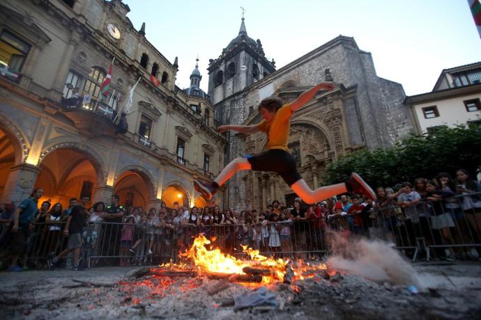 Un joven salta la hoguera de la víspera de San Juan en Hernani